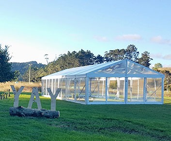 Clear top event tent set up on a green lawn