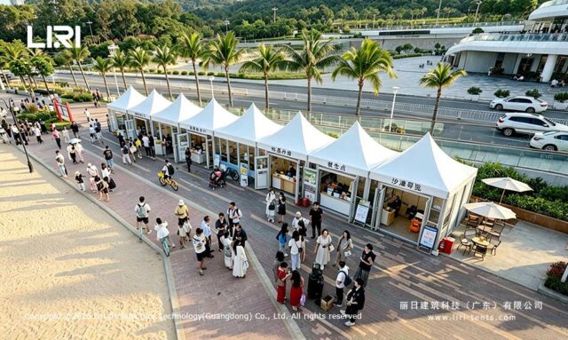 Des boutiques modulaires en forme de pagode, reliées entre elles, le long d'une promenade bordée de palmiers